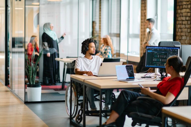 Employees collaborating in a modern workplace aligned with Vision 2030 goals in the Middle East